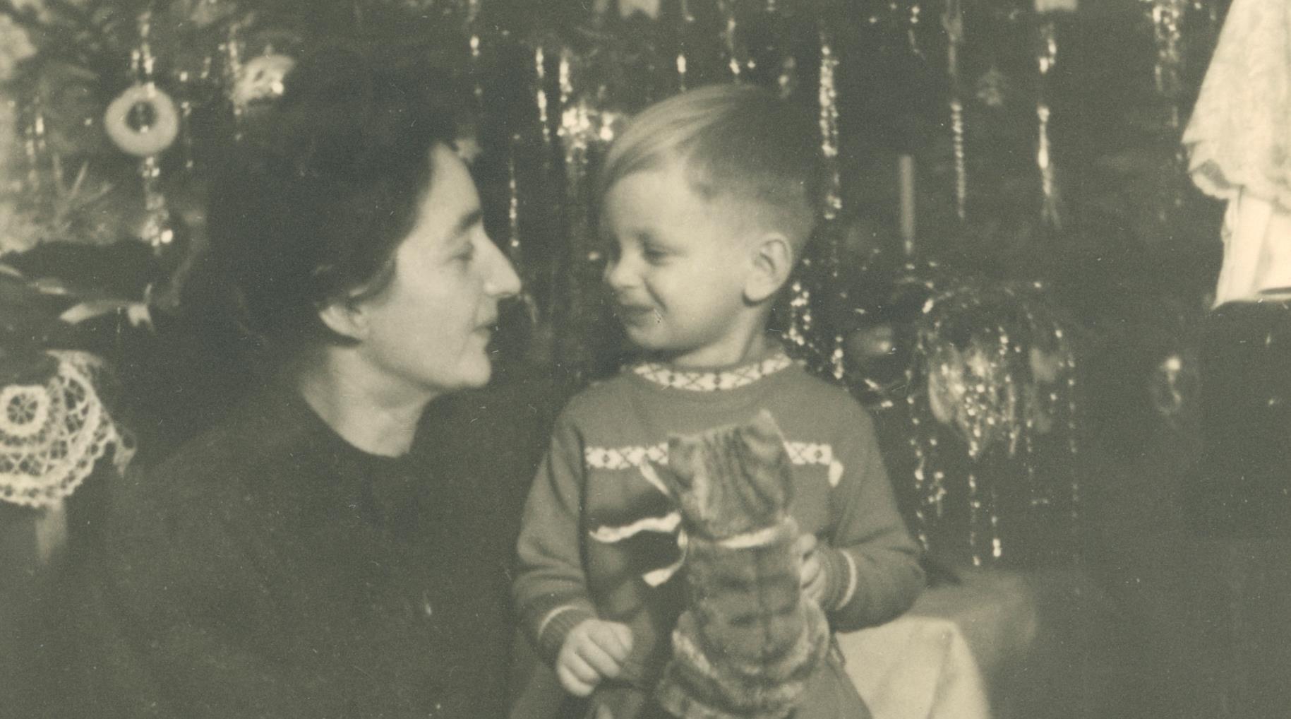 Frau mit Kind vor Weihnachtsbaum mit Lametta