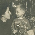 Frau mit Kind vor Weihnachtsbaum mit Lametta