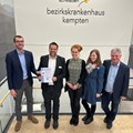 Björn Athmer (IHK-Regionalgeschäftsführer Allgäu; v. l.) überreicht Prof. Dr. Markus Jäger, Tabea Schmid, Theresa Mohr  und Helmut Notz (alle BKH Kempten) die neue EMAS-Urkunde für vorbildlichen Umweltschutz. - Foto: Christian Danner, BKH Kempten