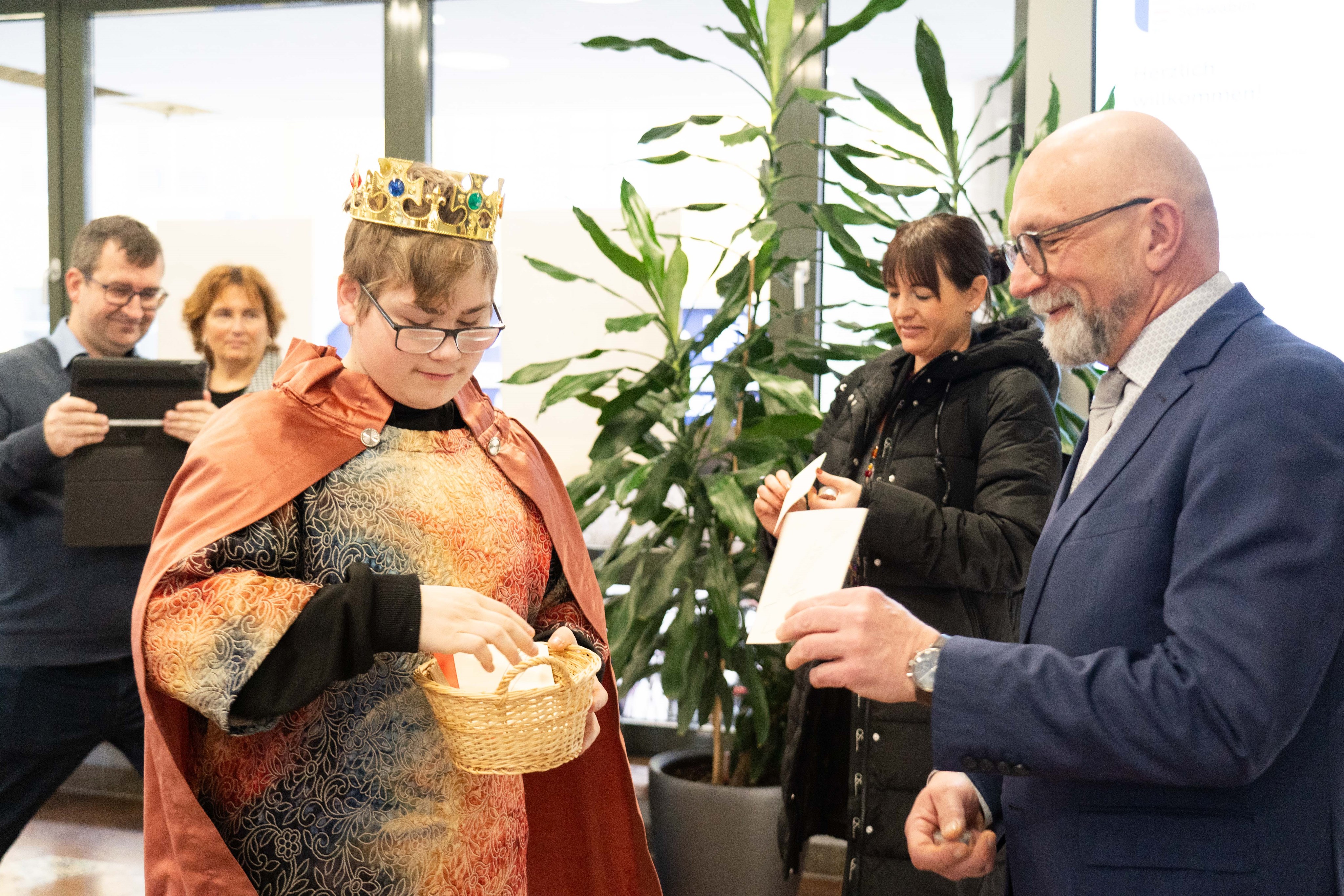 Ein Schüler der Elisabethschule in Aichach verteilt Liedzettel an die Mitarbeitenden des Bezirks Schwaben