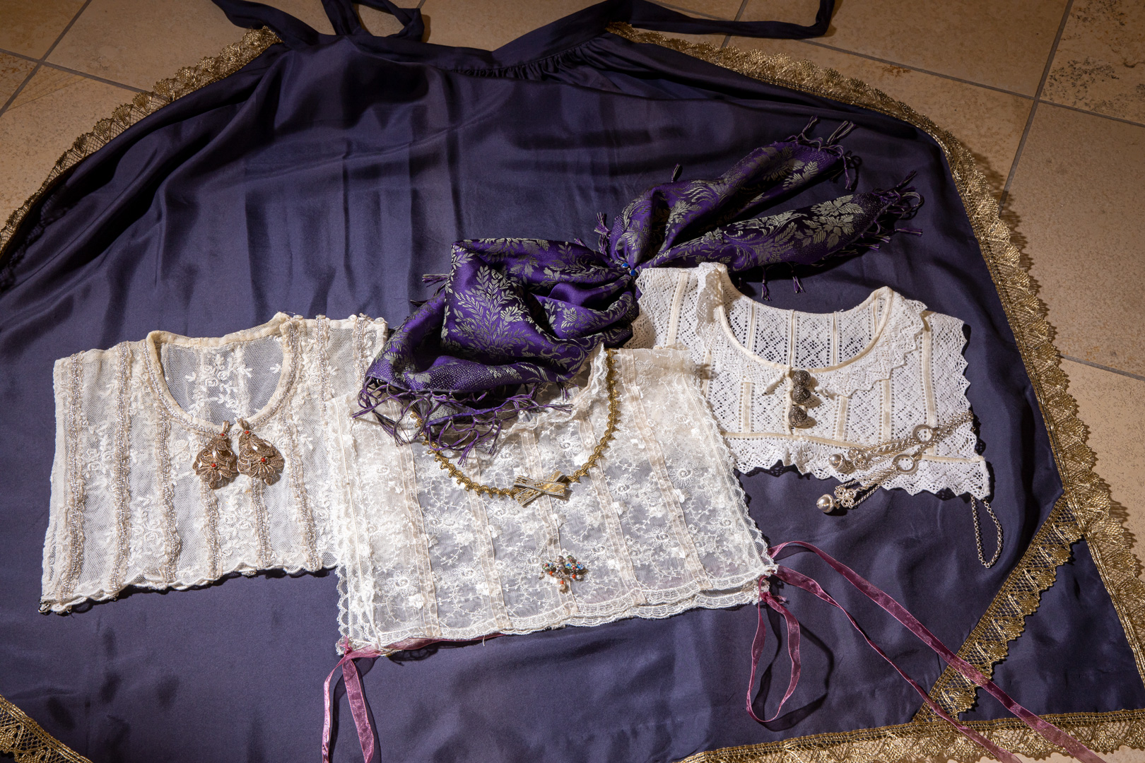 Historische Goller und ihre Verzierungen sind eine wunderbare Inspirationsquelle für das Nähen von Blusen. Foto: Georg Drexel Drei Goller aus weißer Spitze liegen auf einem violetten Hintergrund.