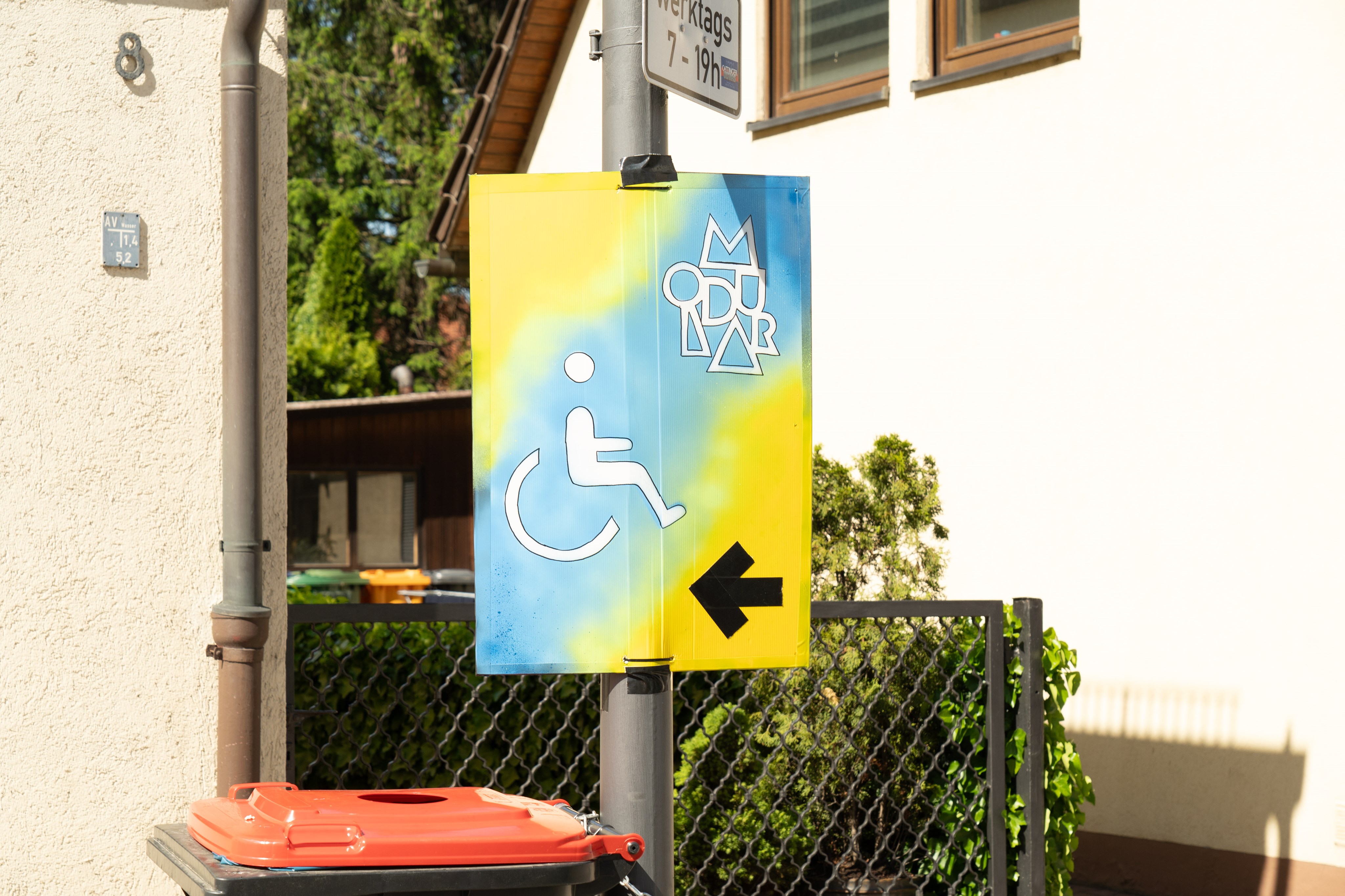 Schild mit Symbol für Rollstuhlfahrer und Richtungspfeil