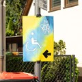 Schild mit Symbol für Rollstuhlfahrer und Richtungspfeil