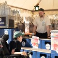 Mann im Rollstuhl im Gespräch mit Mann am Ausschank