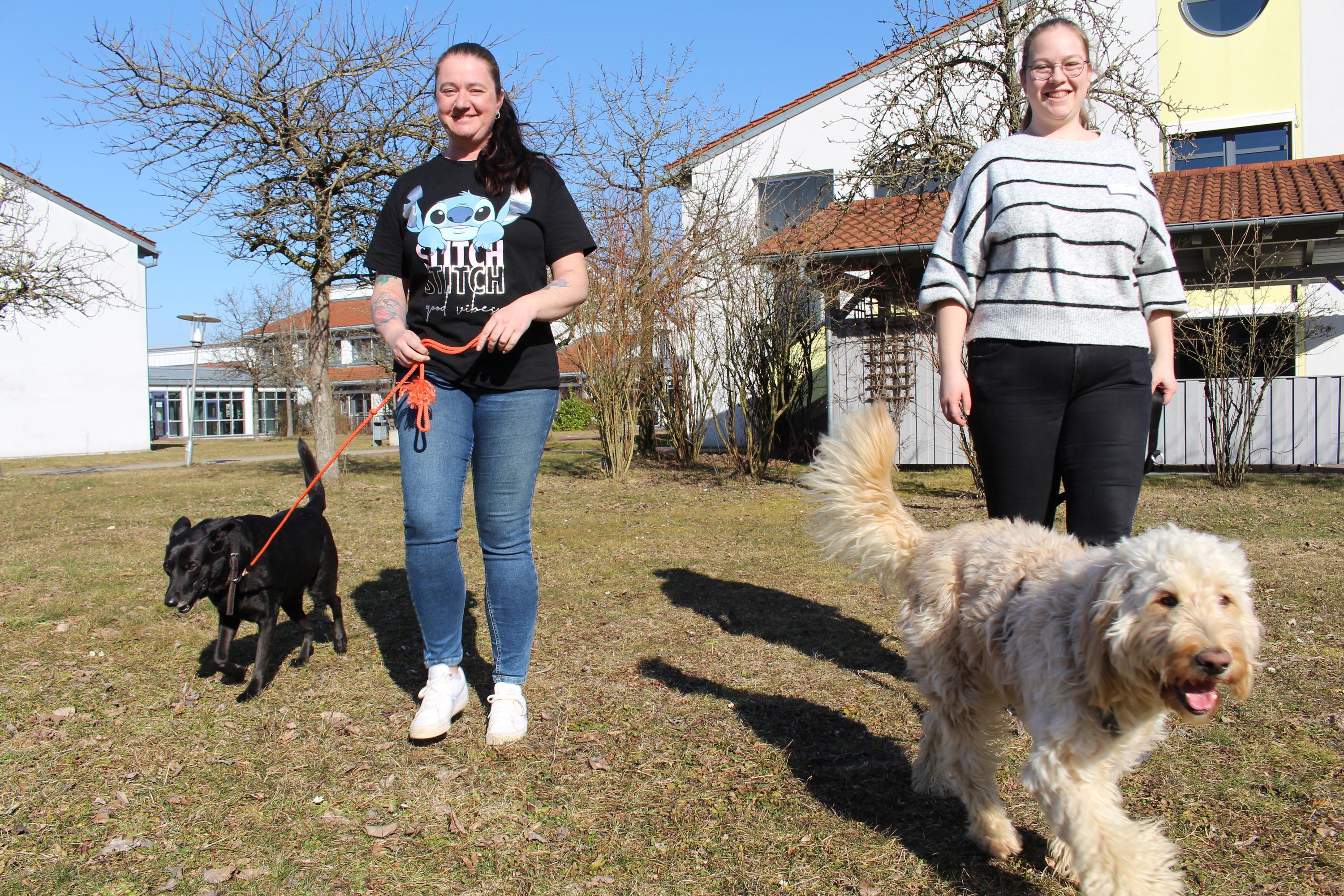 Sarah Brandl (links) und Mona Bäuml haben mit ihren Hunden Luca und Maja (rechts) schon sehr gute Erfahrungen bei der Therapie gemacht. Bild: Georg Schalk, Bezirkskliniken Schwaben