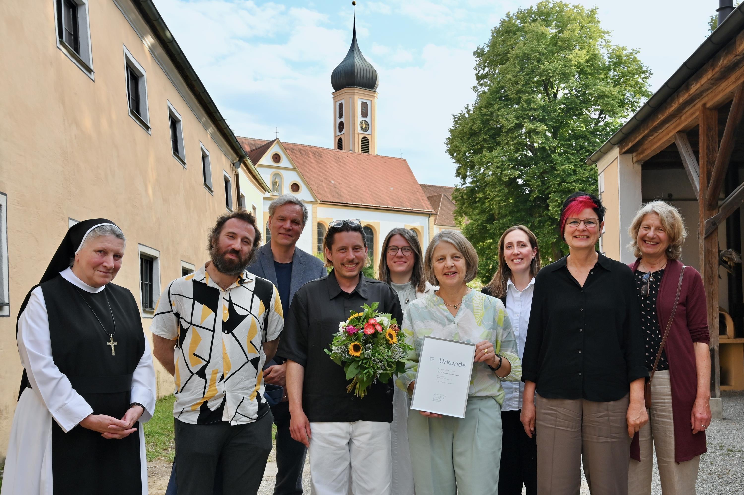 Der Preisträger Jakob Zimmermann (4. v.l.) und Barbara Holzmann, Stellvertreterin des Bezirkstagspräsidenten, (4. v. r.) im Kreise weiterer Gäste. - Foto: Andreas Lode