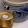 Blau gemusterter Schmalztopf neben Metalldose für Wurst 