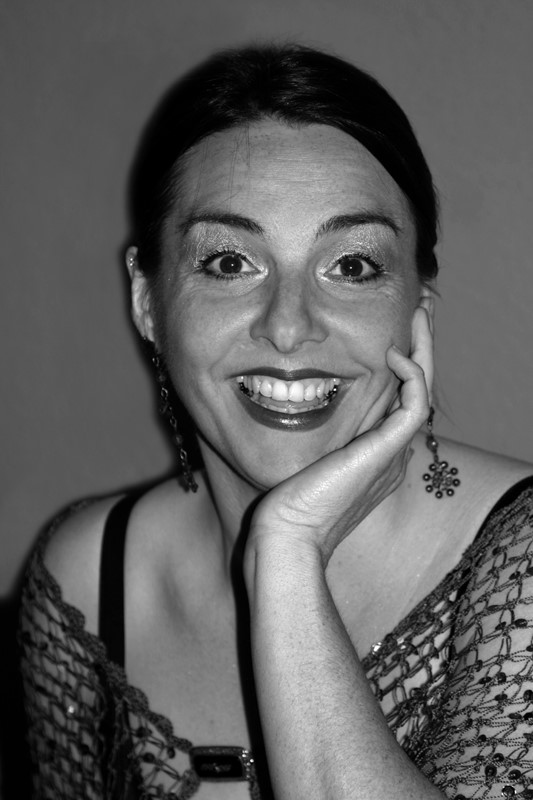 Profilbild: Helga Schuster blickt mit breitem Lächeln in die Kamera