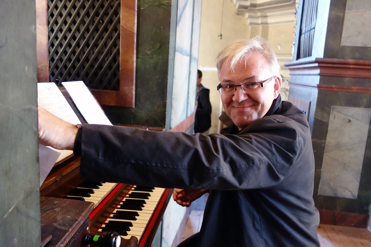 Michael Eberth an der Orgel in Irsee; er lächelt in die Kamera