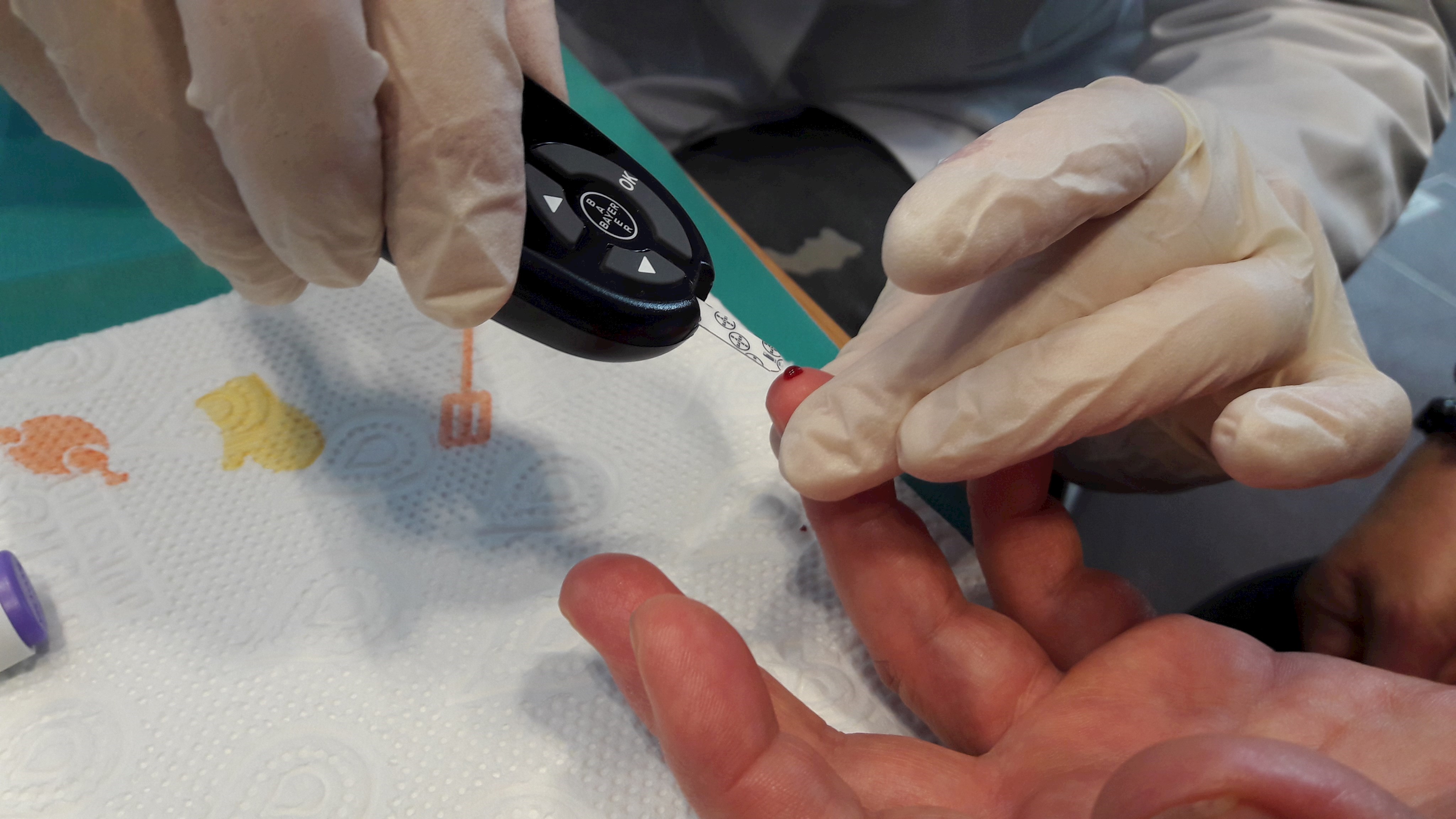 Ein Messgerät berührt einen Bluttropfen an einem Finger, um den Blutzuckerspiegel zu analysieren