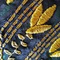 Goldstickerei auf blauem Stoff
