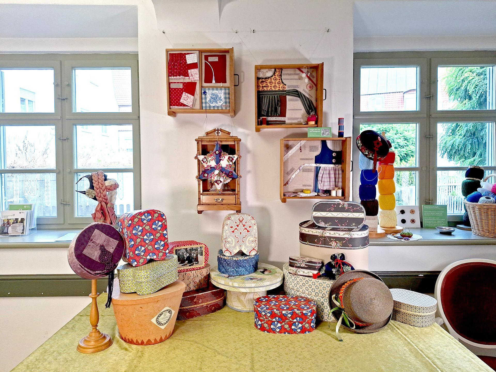 Diverse bunte Hut- und Haubenschachteln auf einem Tisch