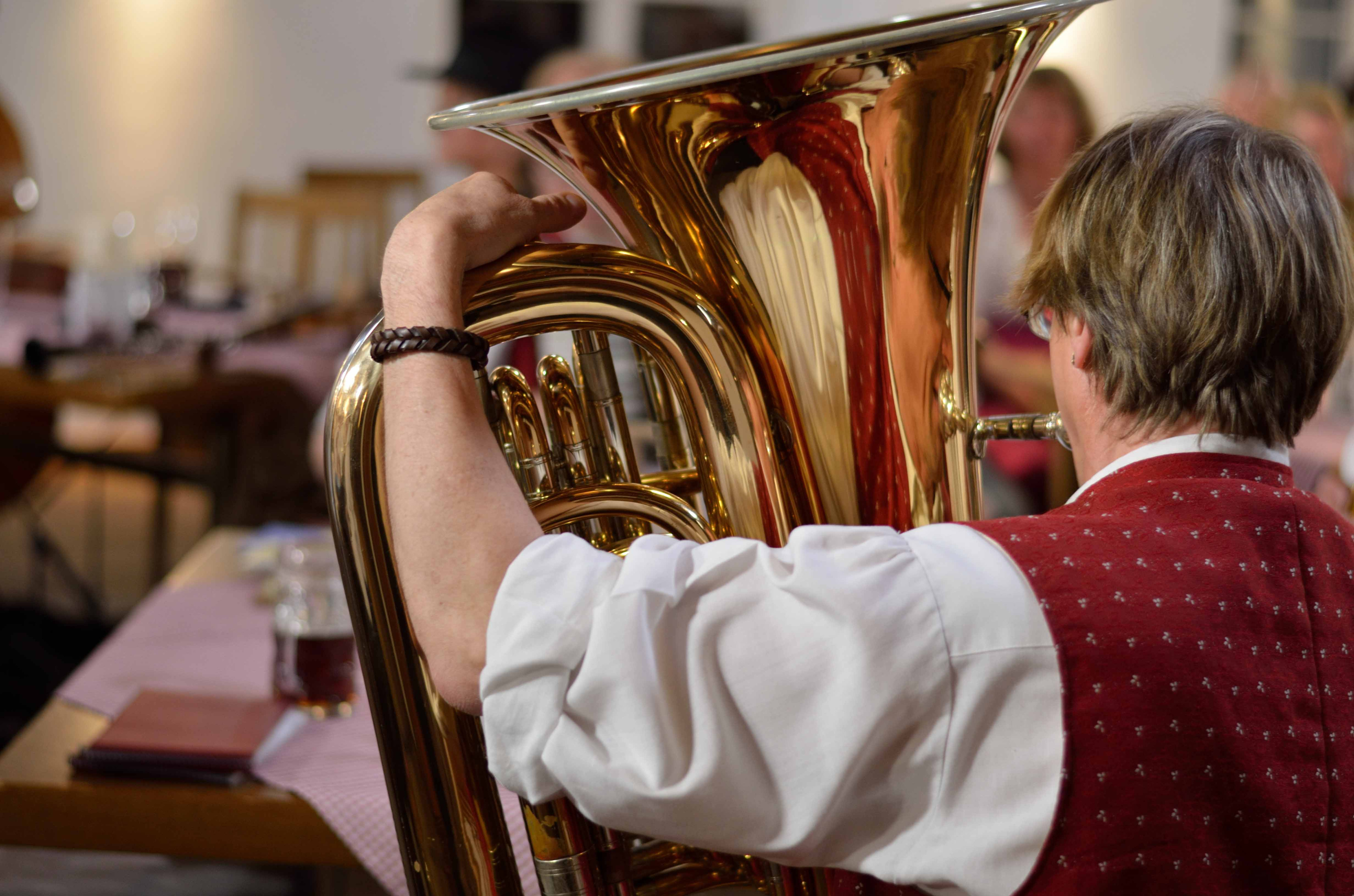 ein Mann in Trachtenkleidung bläst in eine Tuba