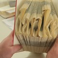 Gefaltete Buchseiten werden in den Wertachtal-Werkstätten zu kleinen Kunstwerken verarbeitet.