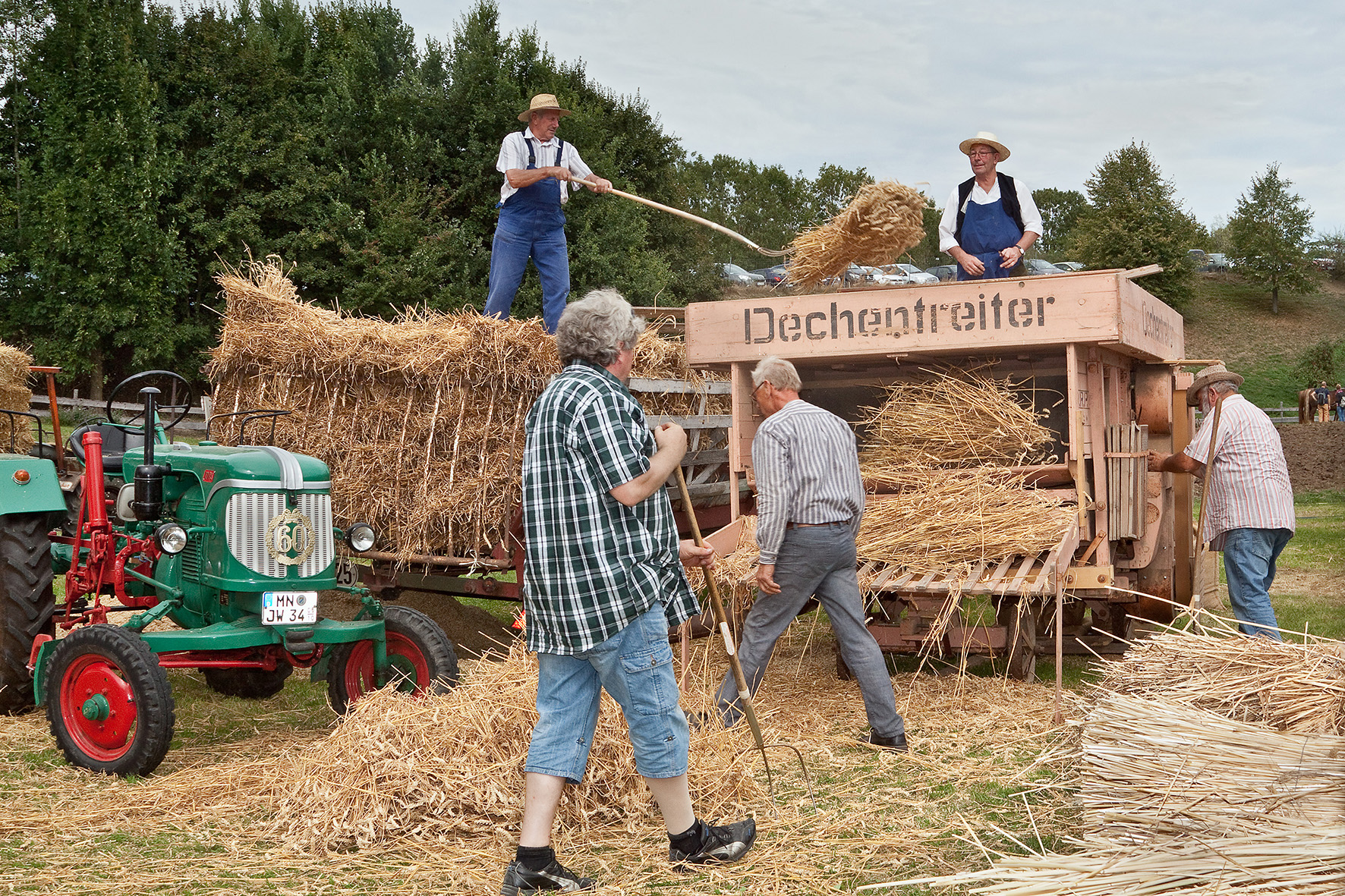 Zwar nicht mehr von Hand gedroschen, aber trotzdem immer noch harte Arbeit: Die Traktorfreunde Illerwinkel e.V. führen
das Dreschen mit der Dreschmaschine vor.