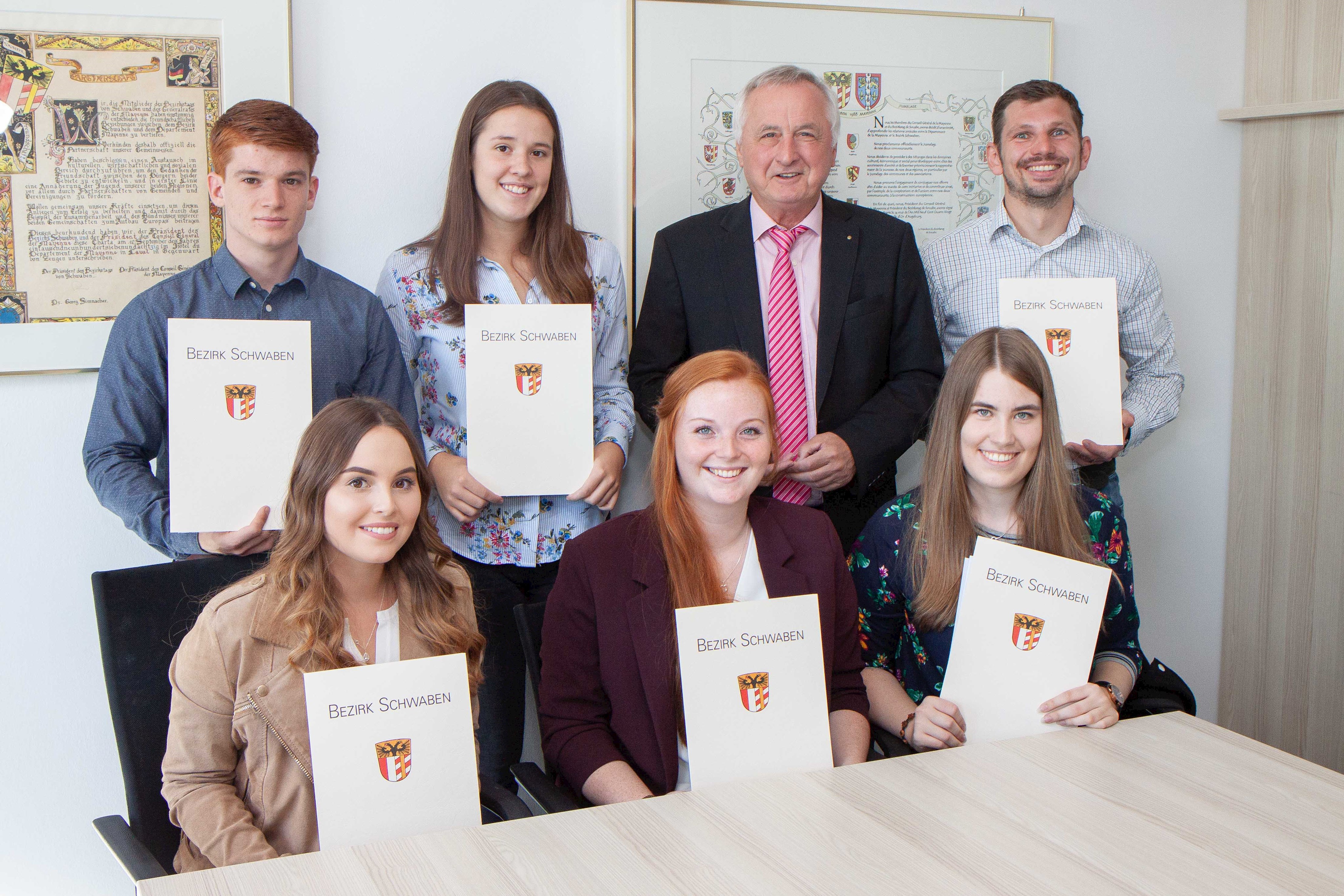 Stehend von links: Valentin Seeberg-Elverfeldt, Lea Bartnik, Bezirkstagspräsident Jürgen Reichert, Thomas Kohnle; sitzend von links: Aurelia Bachmeir, Vanessa Waldek, Elisa Becke. Bei dem Fototermin nicht anwesend war Anwärterin Janine Spreng.