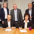 Gregor Beck und Tetiana Zakrutna (vorne) bekräftigten unter den Augen der Partnerschaftsbeauftragten Dr. Katharina Haberkorn, Bezirkstagspräsident Jürgen Reichert und Wolfgang Bähner mit einem Partnerschaftsvertrag eine zukünftige Zusammenarbeit.