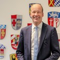 Bezirkstagspräsident Martin Sailer vor den Wappen der schwäbischen Landkreise und kreisfreien Städte