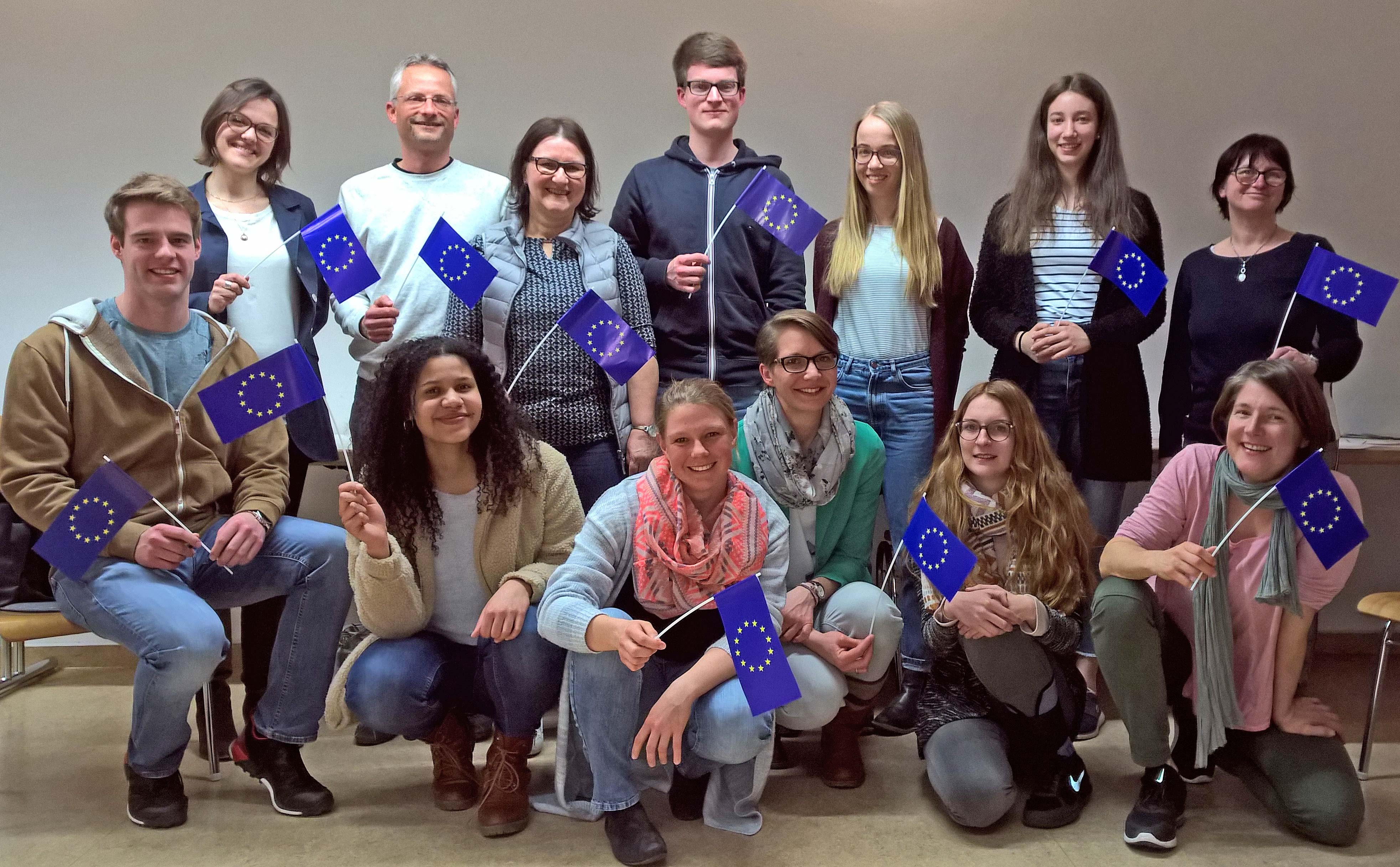 Gruppenbild der Teilnehmer, alle halten kleine Europa-Fahnen in den Händen