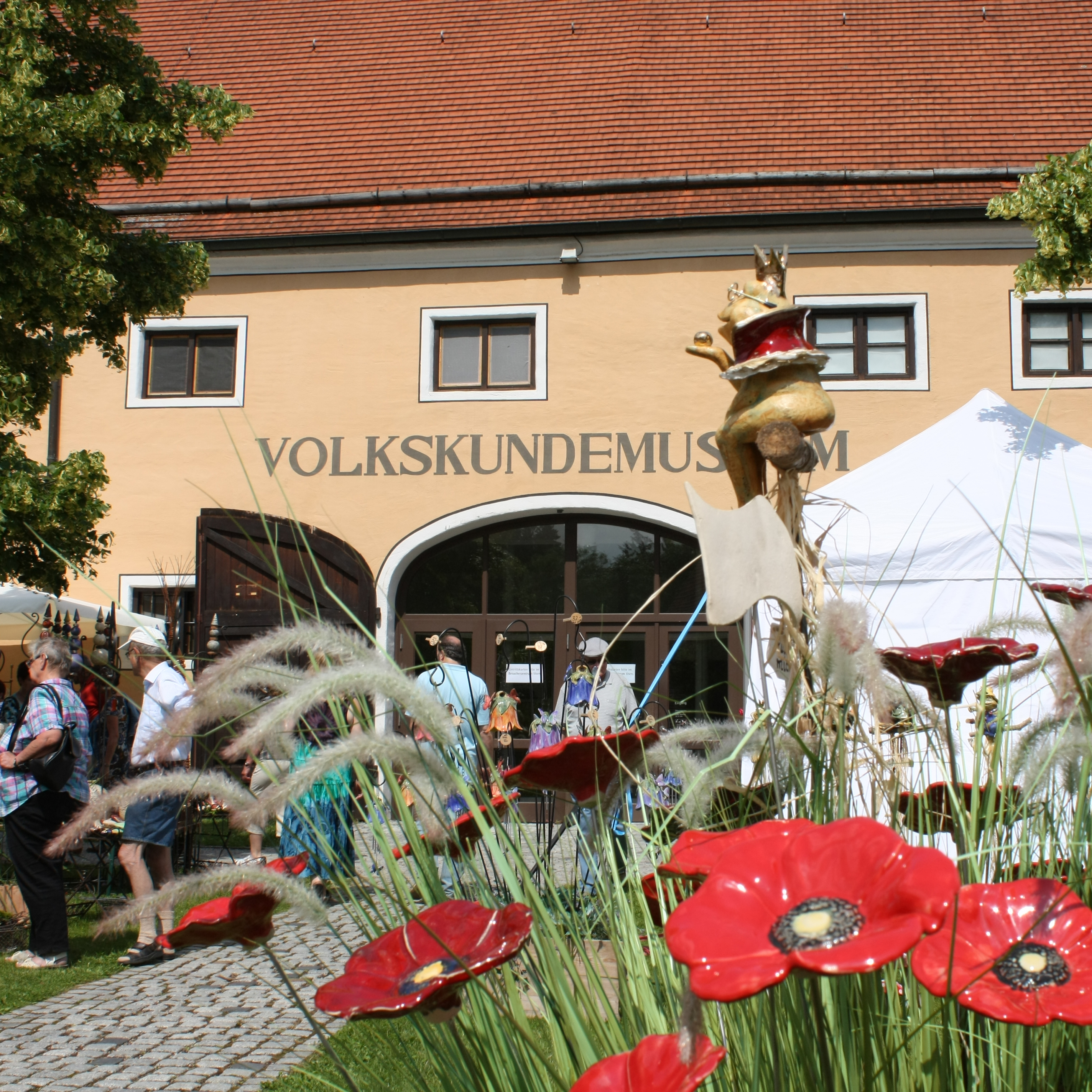 rote Keramik-Mohnblumen vor dem Museumseingang