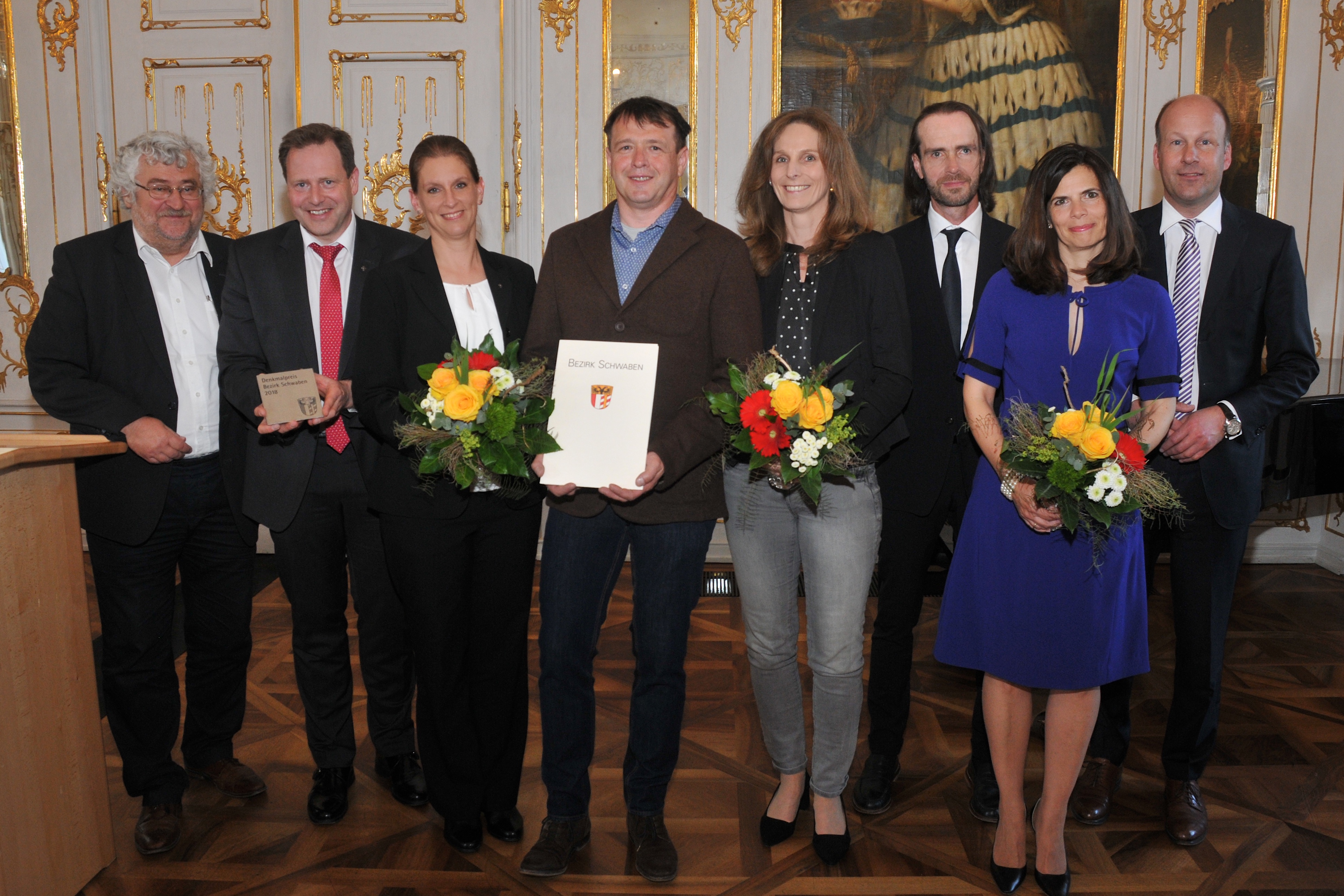 Der Denkmalpreis 2018 geht an die Ev.-Luth. Kirchengemeinde St. Martin in Memmingen, vertreten durch die Dekane Claudia und Schieder (2. und 3. v. l. ). Daneben freuen sich zwei Sonderpreis-Träger: Dominikus Schnitzer und Gattin (Augsburg) sowie das Ehepaar Roland und Christine Schmailzl (Gersthofen). Den stimmigen Rahmen bilden Bezirksheimatpfleger Dr. Peter Fassl (l.)  und Bezirkstagspräsident Martin Sailer (r.).