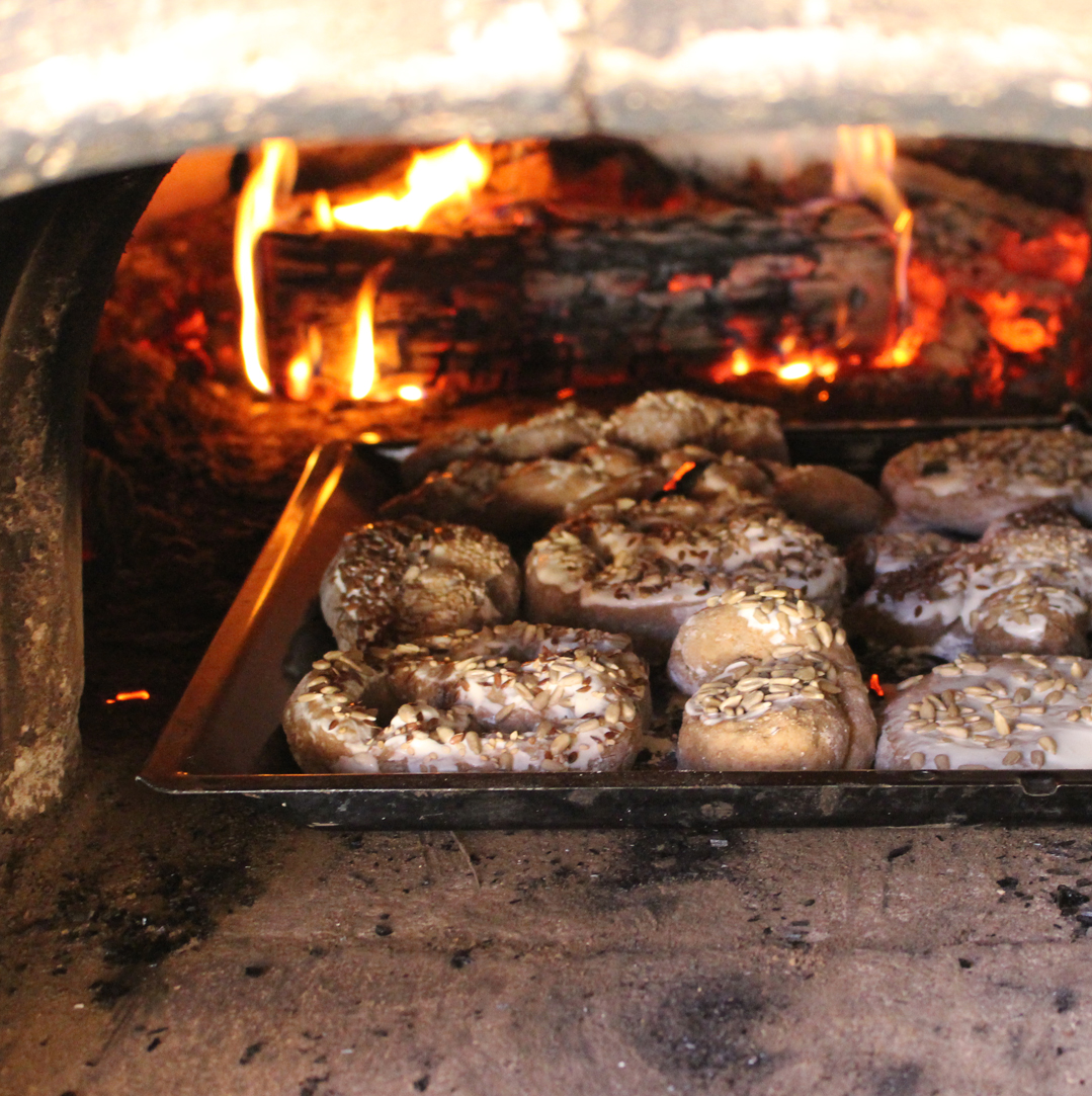 Feuer im Holzofen darin ein Blech mit selbst gemachten kleinen Broten