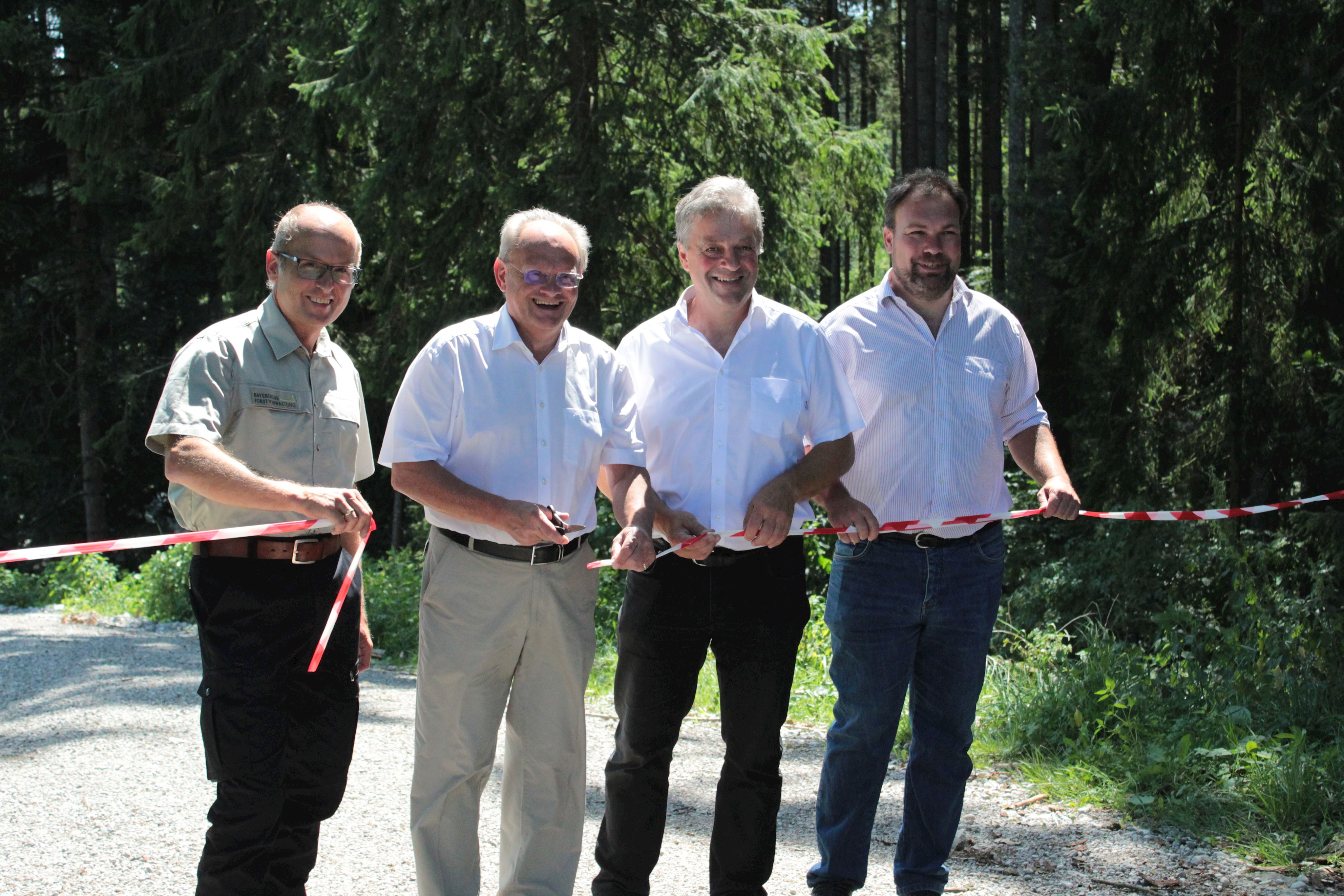 Auf dem Bild von links: Frank Kroll, stellvertretender Bezirkstagspräsident Alfons Weber, Andreas Lieb, 1. Bürgermeister Markt Irsee und Simon Östreicher, Betriebsleiter für Waldflächen des Bezirks Schwaben beim Amt für Ernährung, Landwirtschaft und Forsten Kaufbeuren bei der Eröffnung des Höllwegs.