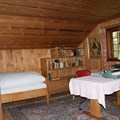 Zimmer mit hölzernen Wänden und Möbeln, Schreibmaschine auf dem Tisch