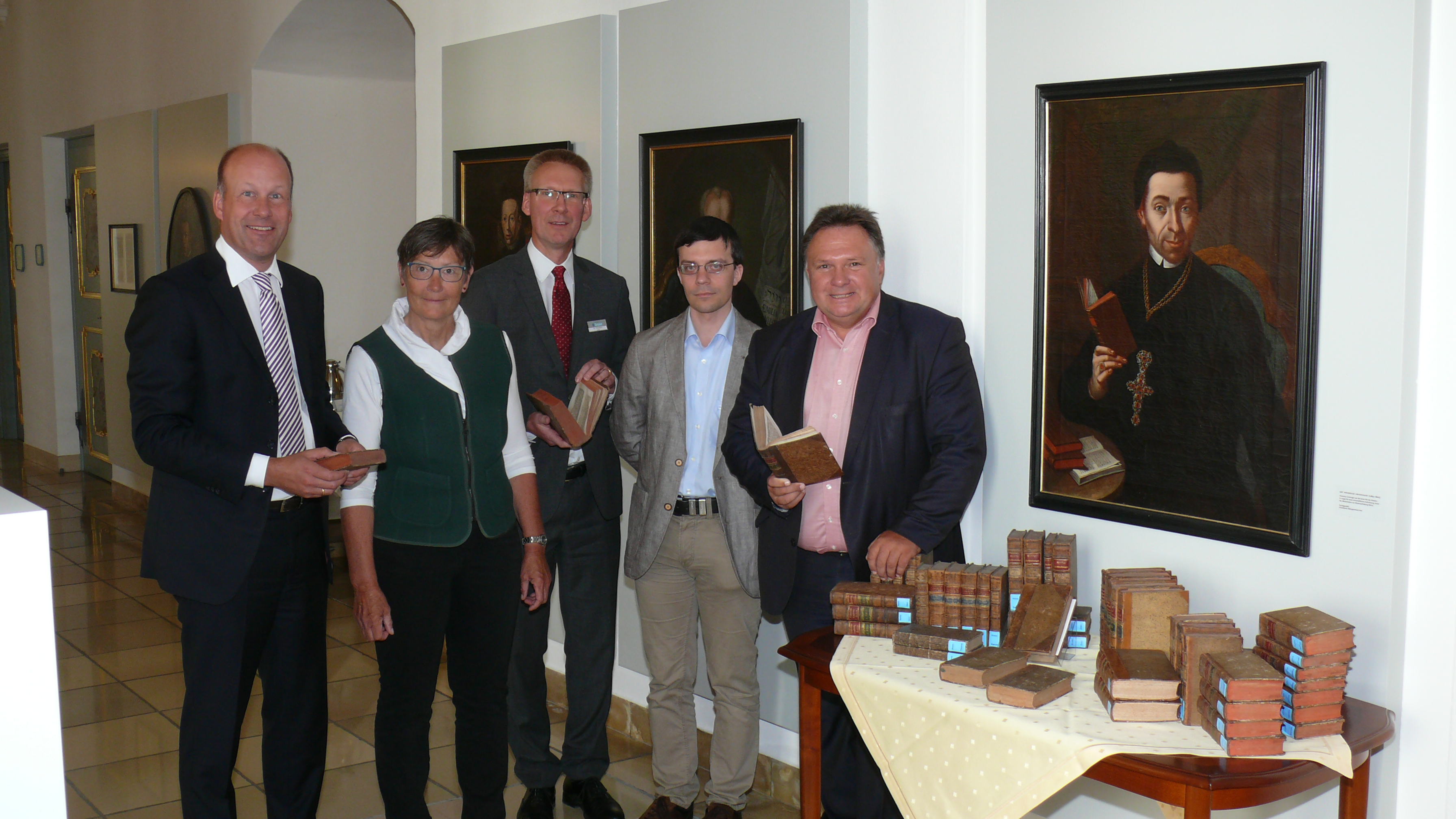 Das Foto von der Buchübergabe zeigt vor dem Porträt von Abt Honorius Grieninger in Kloster Irsee: Bezirkstagspräsident Martin Sailer (l.) und Oberbürgermeister Stefan Bosse (r.) sowie Verna Bickel und Dr. Peter Keller (Stadtarchiv Kaufbeuren) mit Dr. Stefan Raueiser (Mitte), Leiter des Schwäbischen Bildungszentrums.