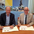 Freuen sich auf mehr Kooperation: Bezirkstagspräsident Martin Sailer (links) und Landrat Dr. Klaus Metzger beim Unterschreiben der Vereinbarung für mehr Zusammenarbeit im Sozialbereich.