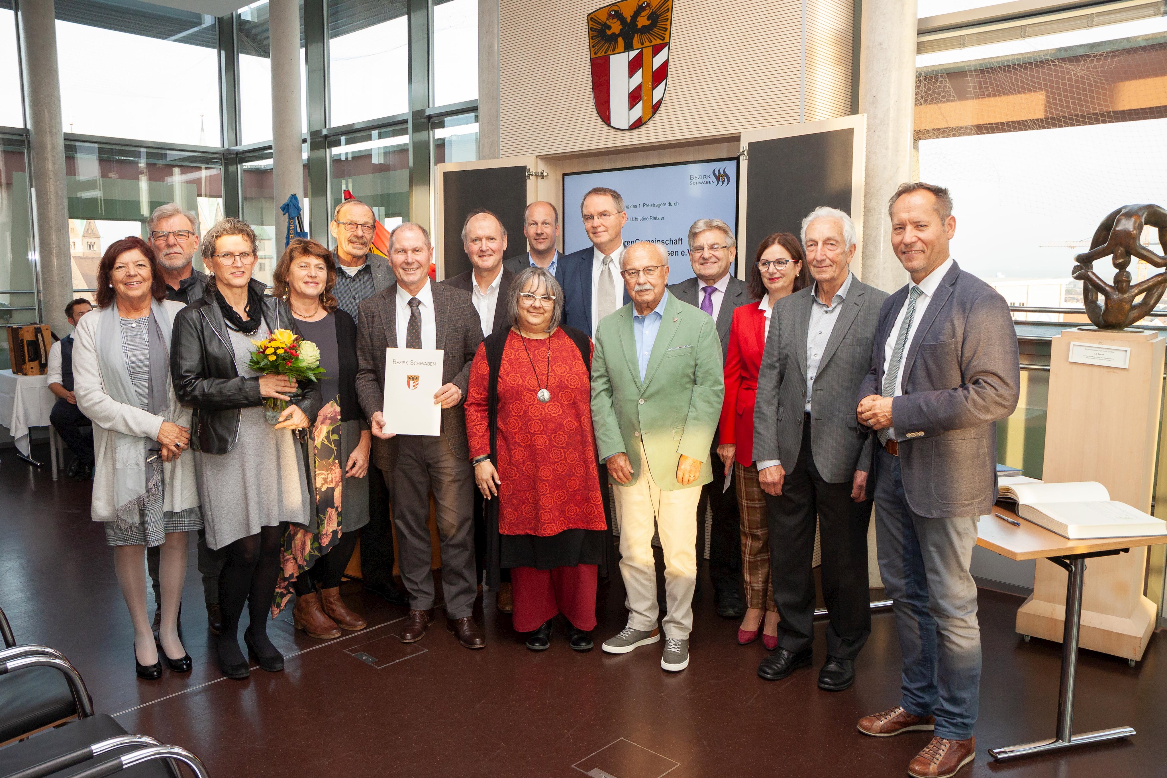 Mit dem Vereinsvorstand freuten sich Bezirksrätin Christine Rietzler (4. von links), die als Pflegebeauftragte des Bezirkstags auch die Laudatio hielt, Bezirksrat Dr. Johann Popp (7.v.links), Bezirksrätin Heidi Terpoorten (vordere Reihe, Bildmitte), Bezirkstagspräsident Martin Sailer (hintere Reihe, 9.v.links), Bezirksrat Volkmar Thumser (hintere Reihe, 6.v. rechts), Dillingens stellvertretender Landrat Alfred Schneid (hintere Reihe, 5.v. rechts), sowie Wertingens Bürgermeister Willy Lehmeier.