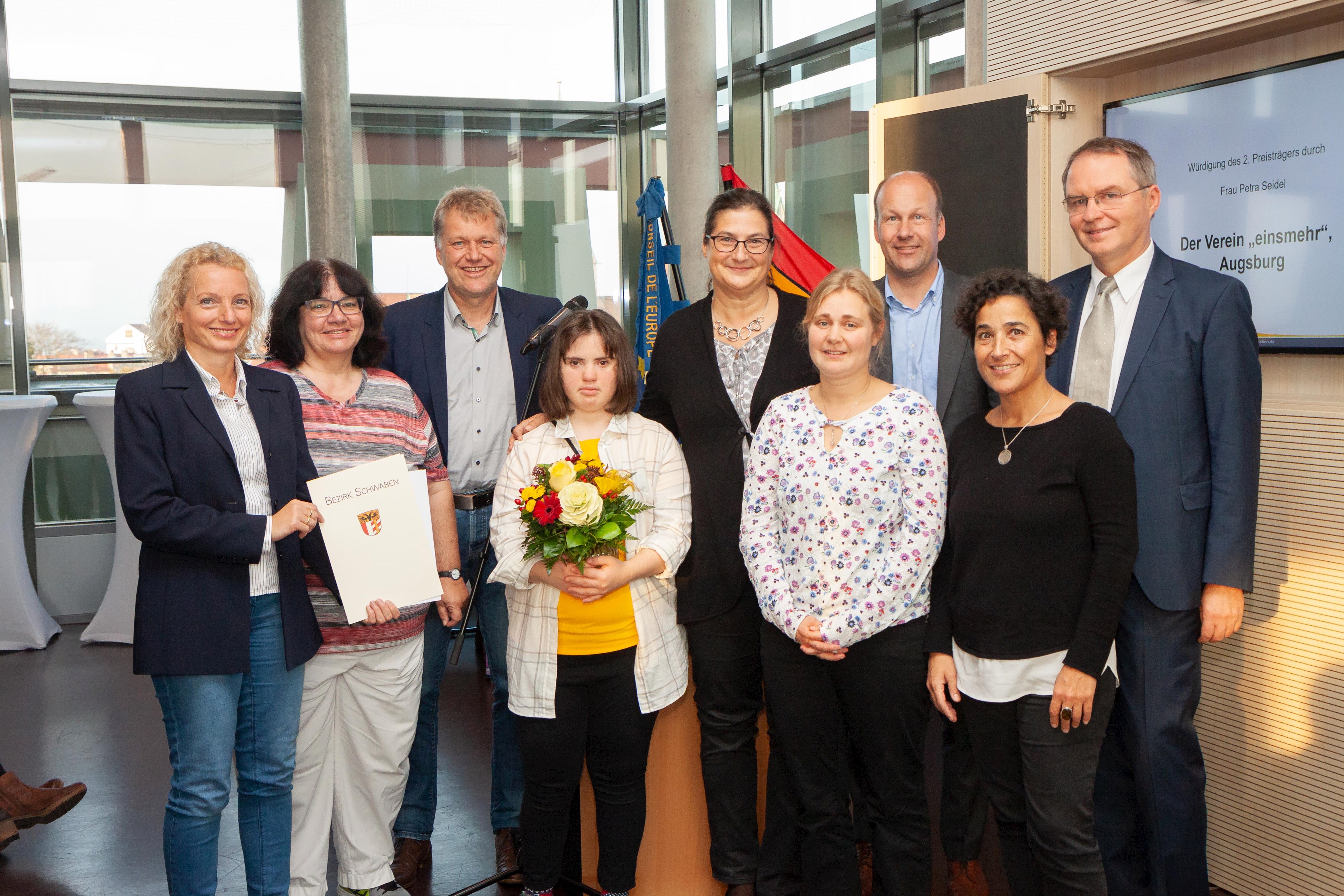 Mit im Bild: Bezirksrat Volkmar Thumser, zugleich auch Inklusionsbeauftragter des Schwäbischen Bezirkstags (rechts), Bezirkstagpräsident Martin Sailer (2. von rechts) und Laudatorin Kerstin Asmussen von der Kontaktstelle für Selbsthilfegruppen in Augsburg (vorne, 2. von rechts).