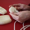 Hände einer Frau, die einen ovalen Wachsstock wickelt