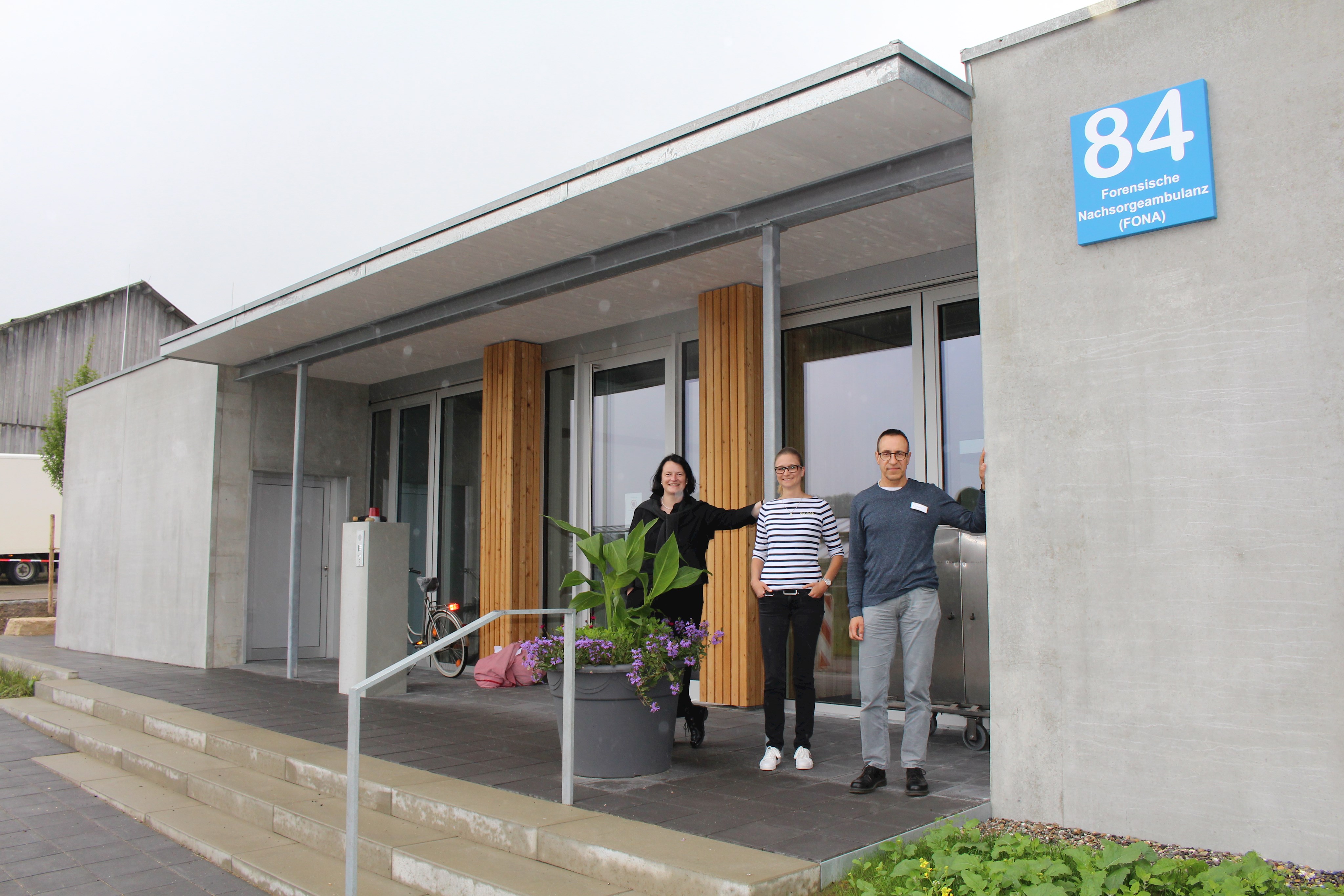 Am Eingangsbereich der neuen FONA (Haus 84): (von links) Prof. Dr. Manuela Dudeck, Ärztliche Direktorin der Klinik für Forensische Psychiatrie und Psychotherapie, Mitarbeiterin Natascha Becker und Einrichtungsleiter Dr. Dieter Hagmayer.