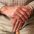 Älterer Herr stützt sich auf Gehstock ab