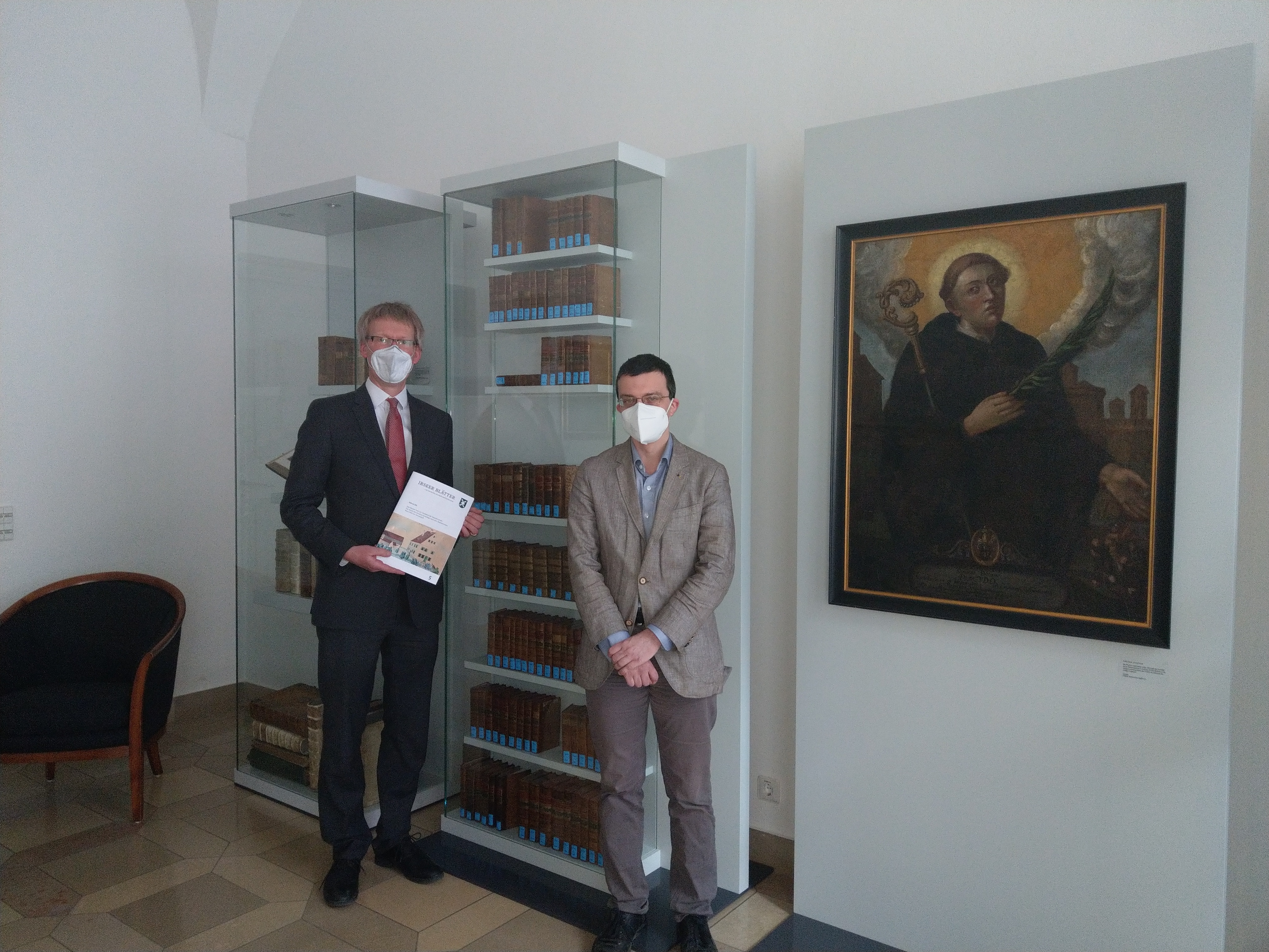 Dr. Stefan Raueiser (links) mit Dr. Peter Keller (rechts) vor der neu geschaffenen Ausstellungsvitrine mit den Büchern aus dem Nachlass von Abt Honorius Grieninger.