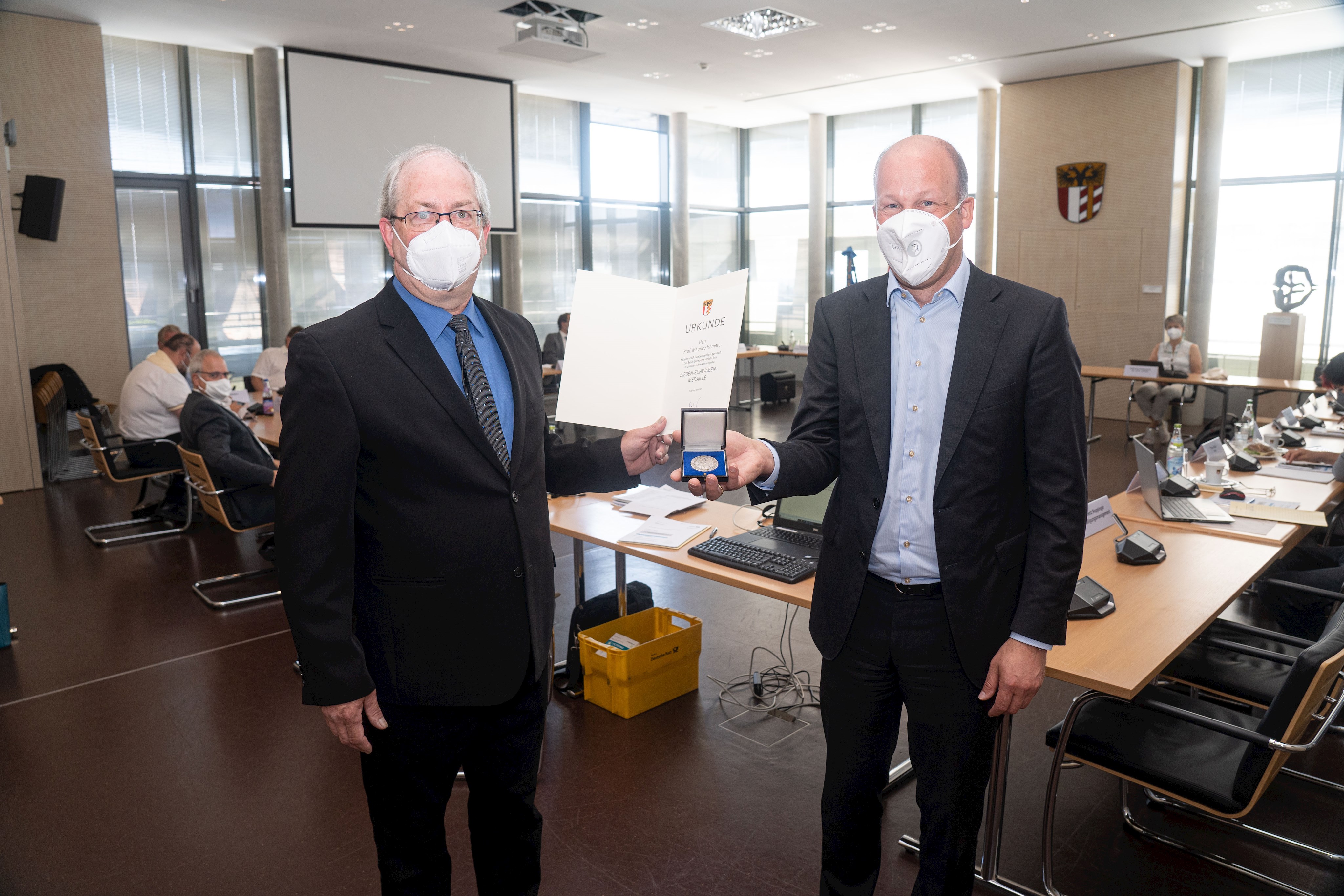 Bezirkstagspräsident Martin Sailer übergibt Prof. Maurice Hamers die 7 Schwaben-Medaille und eine Urkunde im Rahmen des Kultur- und Europaausschusses des Bezirks Schwaben.