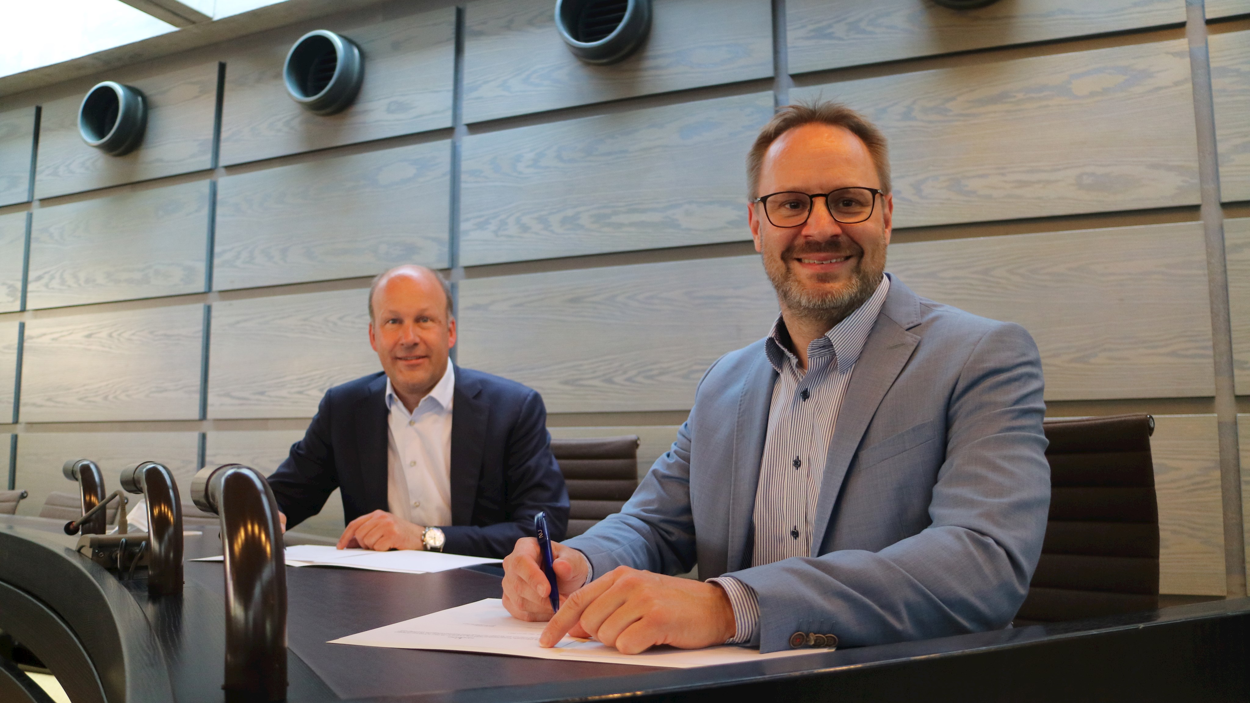 Bezirkstagspräsident Martin Sailer (links) und Landrat Thorsten Freudenberger unterzeichnen den Kooperationsvertrag.