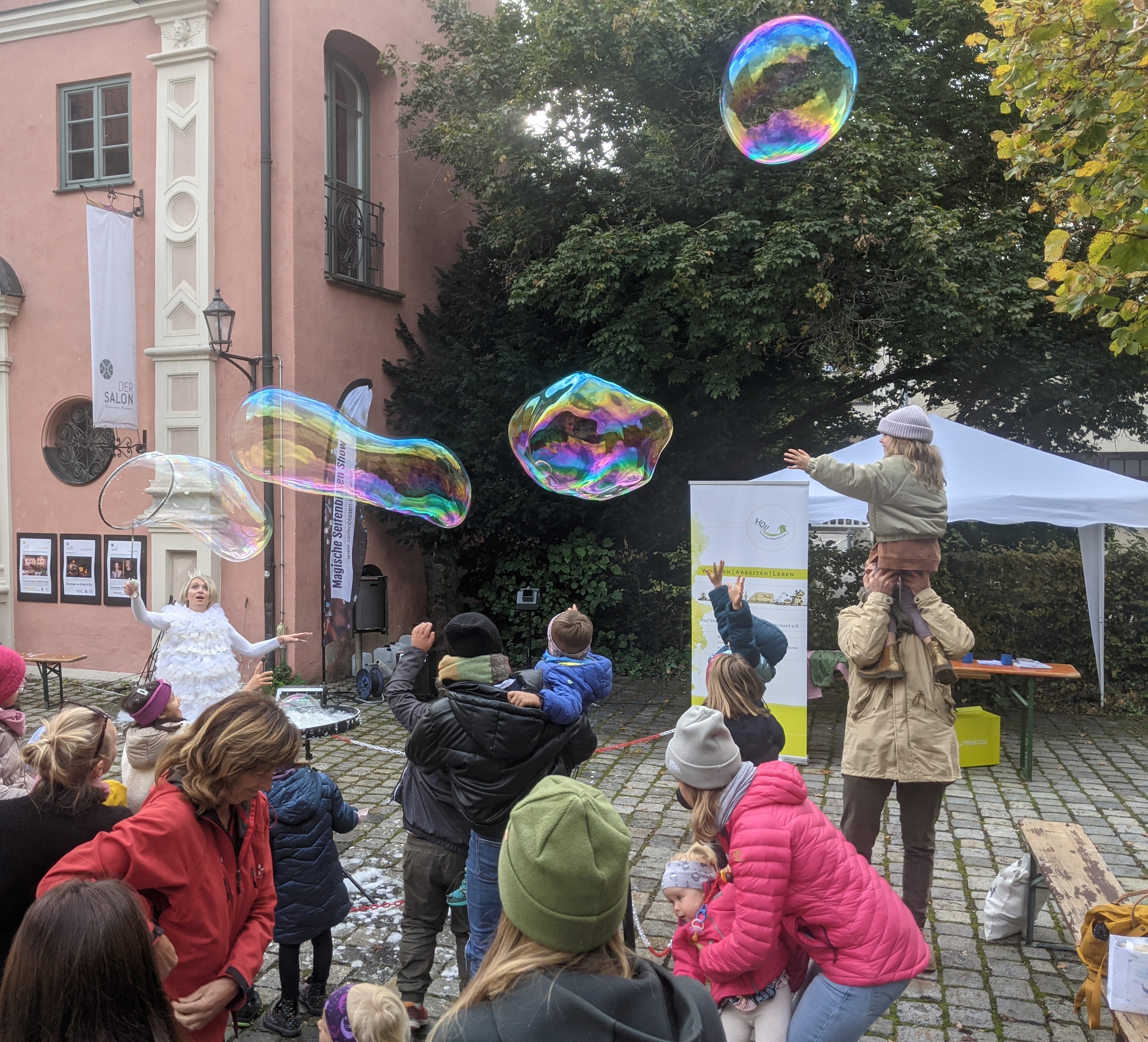Menschen erfreuen sich an der Darbietung einer Seifenblasenkünstlerin