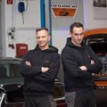 zwei Männer, einer davon mit Hörgerät, in einer Autowerkstatt zwei Männer, einer davon mit Hörgerät, in einer Autowerkstatt