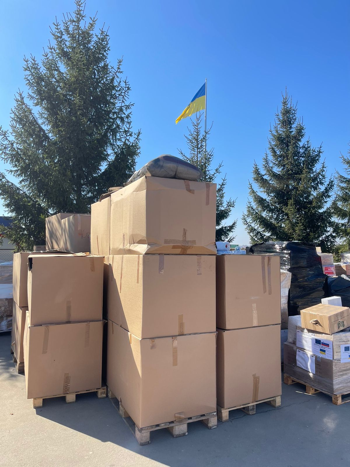 große Kartons, im Hintergrund eine Ukraine-Fahne