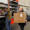 Mitarbeitende der Bezirksverwaltung und Bezirkstagspräsident Martin Sailer (rechts) verladen Winterkleidung, medizinischen Hilfs- sowie Nahrungsmitteln für die ukrainische Partnerregion Tscherniwzi. - Foto: Elisabeth Heisig