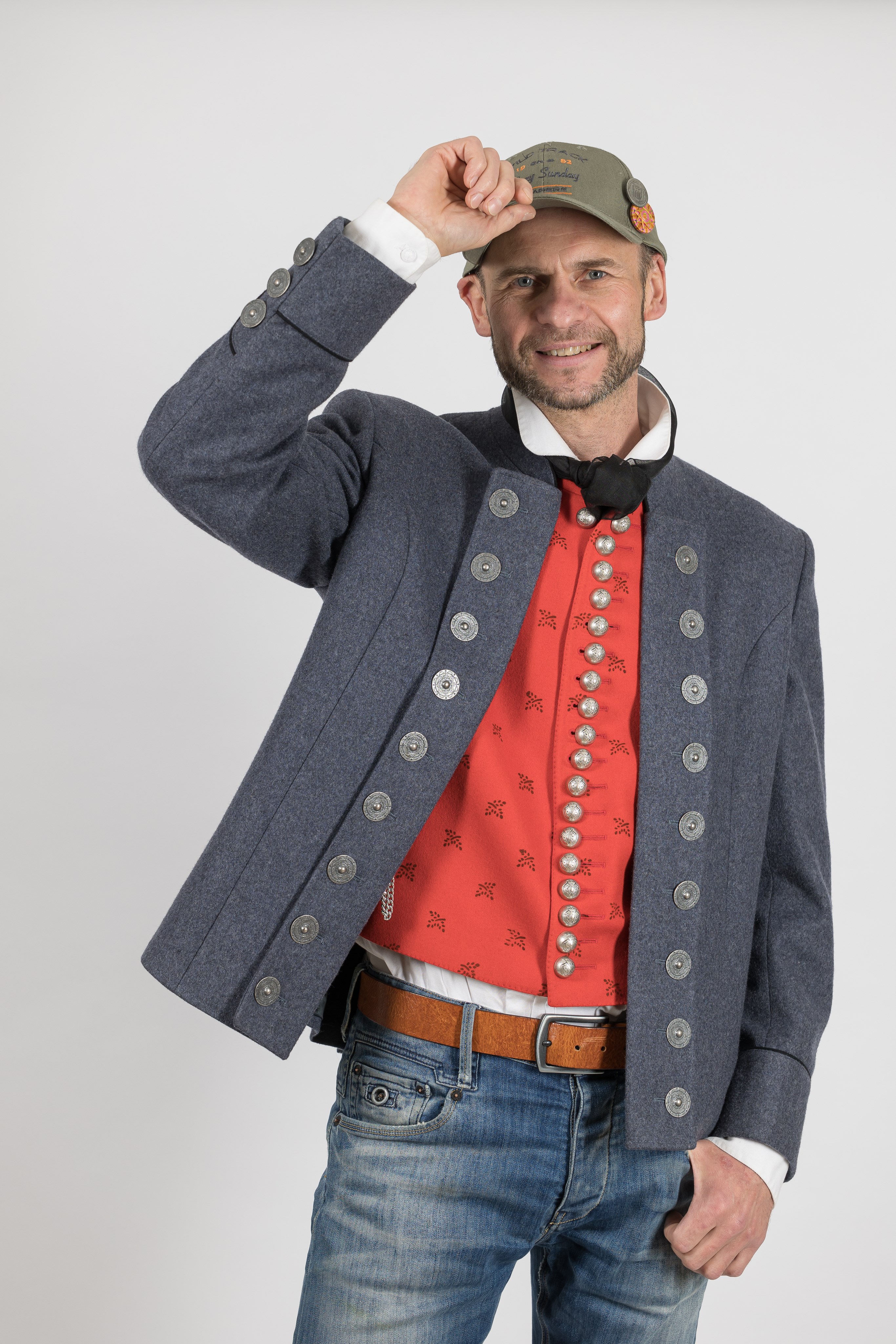 Ein Mann mit roter Weste und grau-blauer Jacke