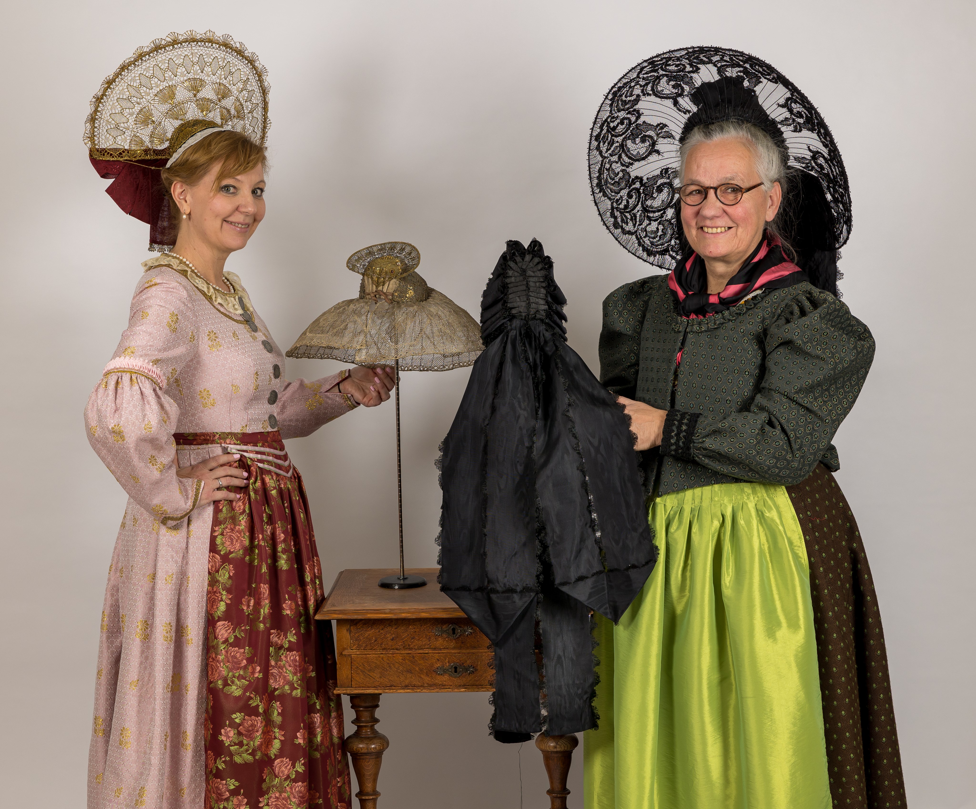 Zwei Frauen in Tracht tragen aufwendige Hauben