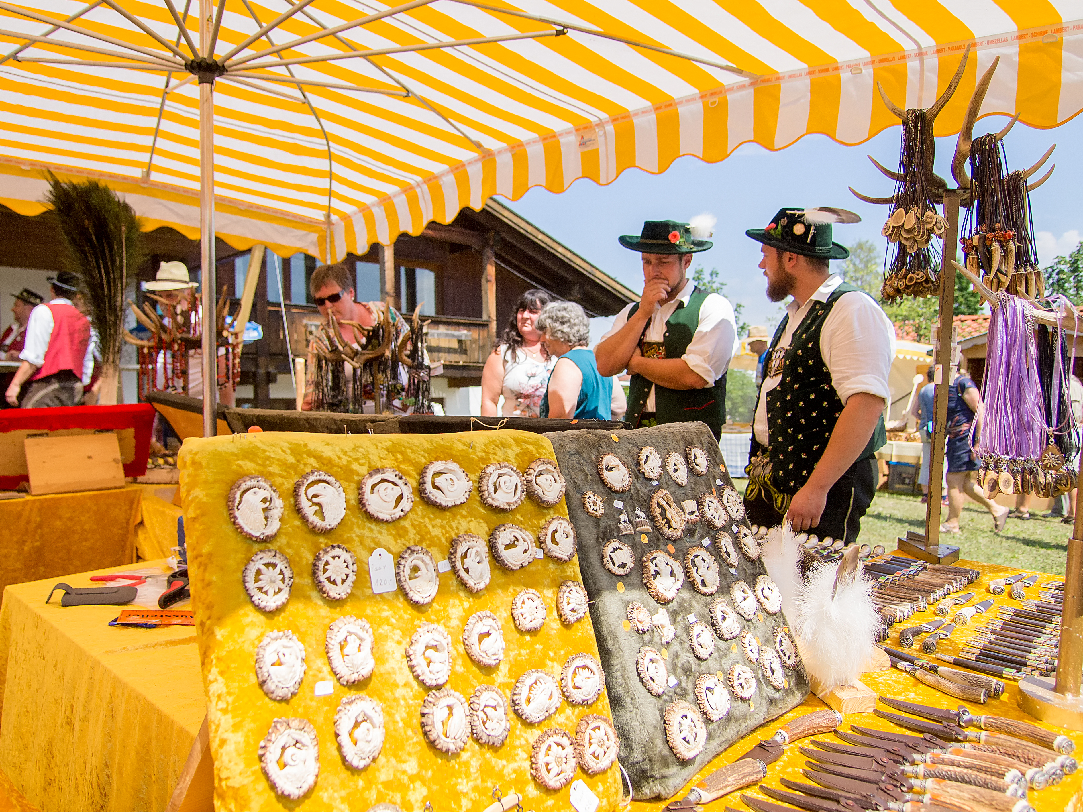 Trachtenmarkt Pfronten Zwei Trachtler unterhalten sich vor einem Stand auf dem Pfrontener Trachtenmarkt