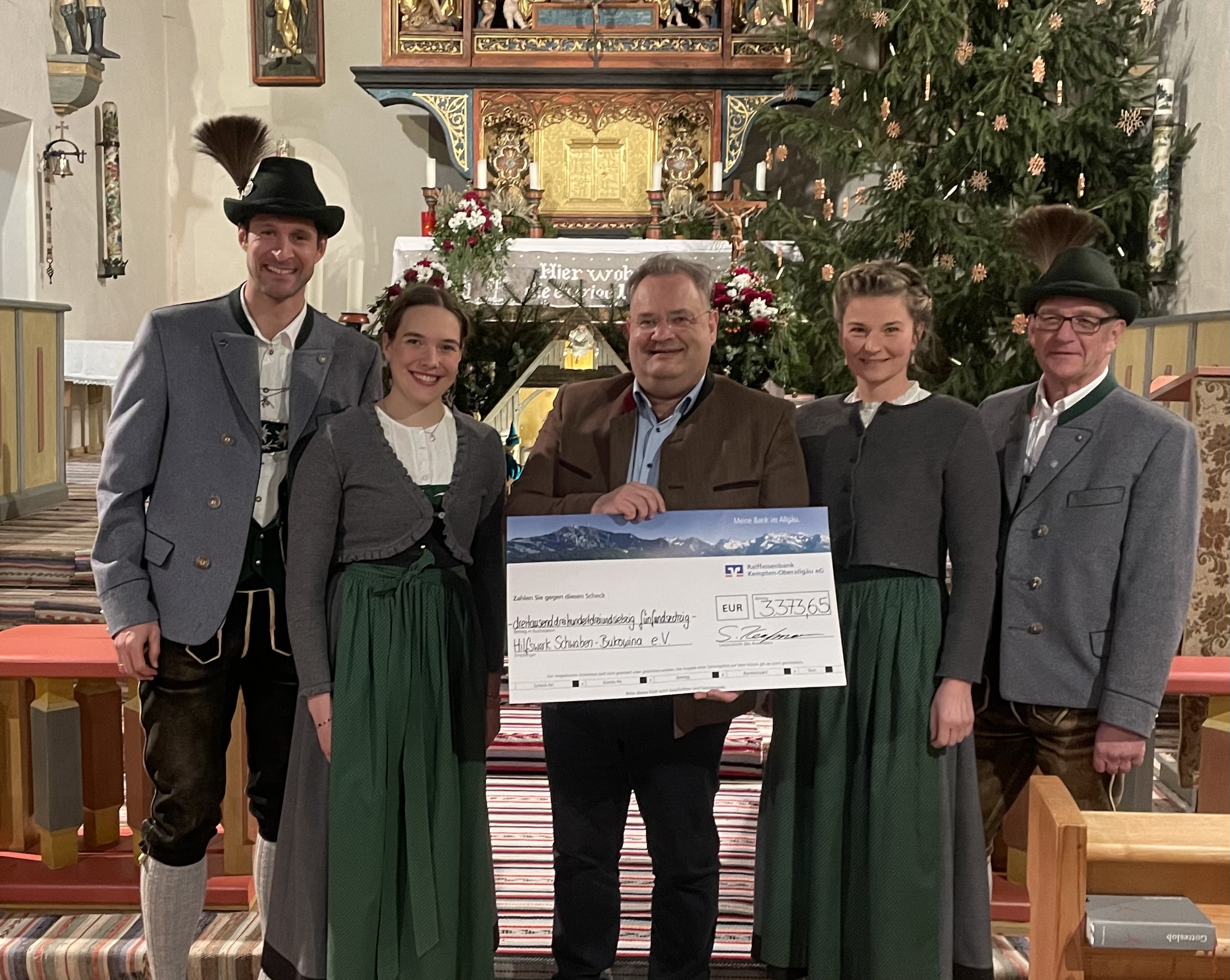 Das Bild zeigt die symbolische Spendenübergabe der Jodlergruppe gemeinsam mit dem stellvertretenden Bezirkstagspräsidenten Edgar Rölz (Mitte).